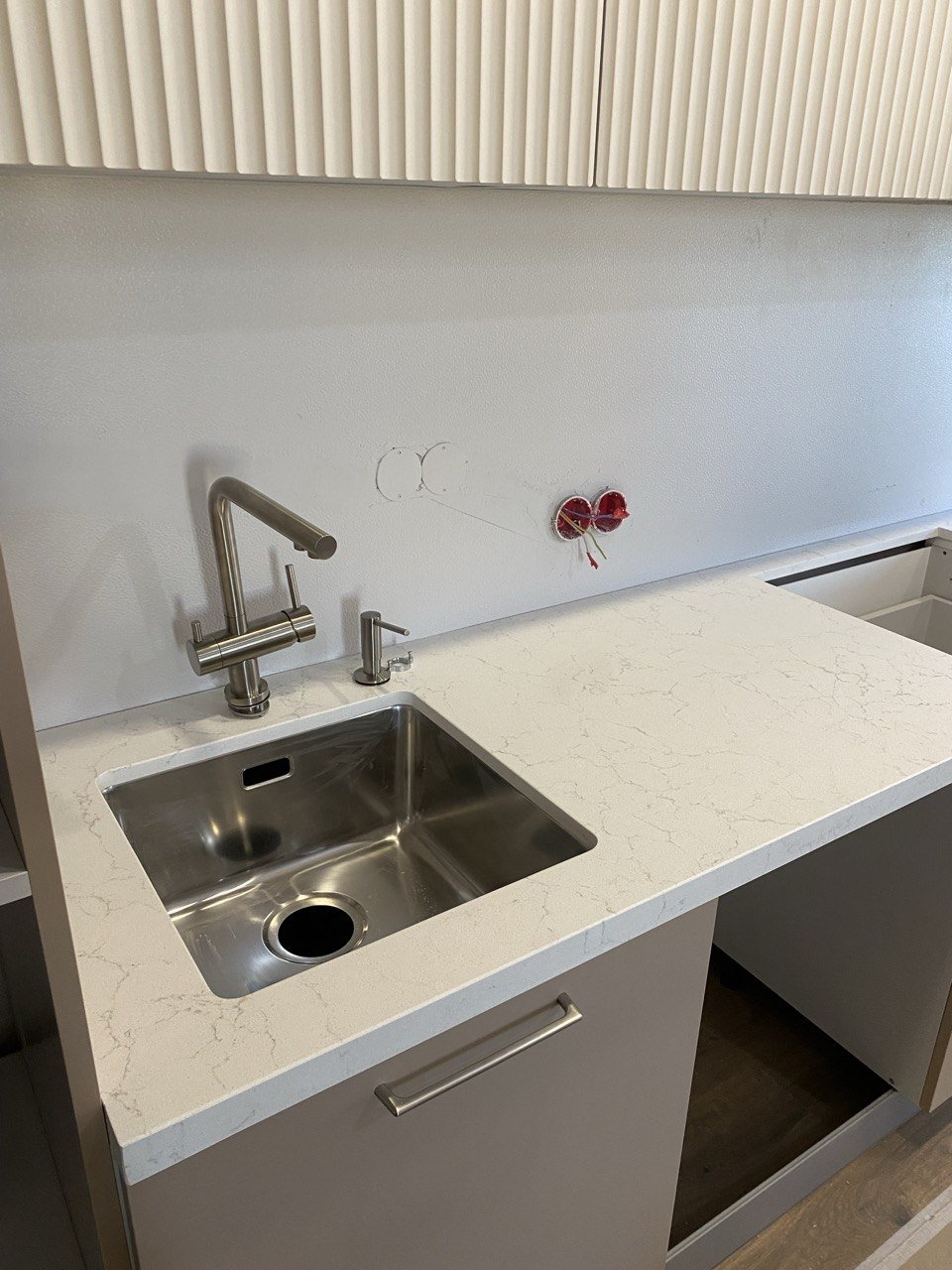 Столешница из кварца Vicostone Valley White с вклеенной стальной мойкой после монтажа — Медведково