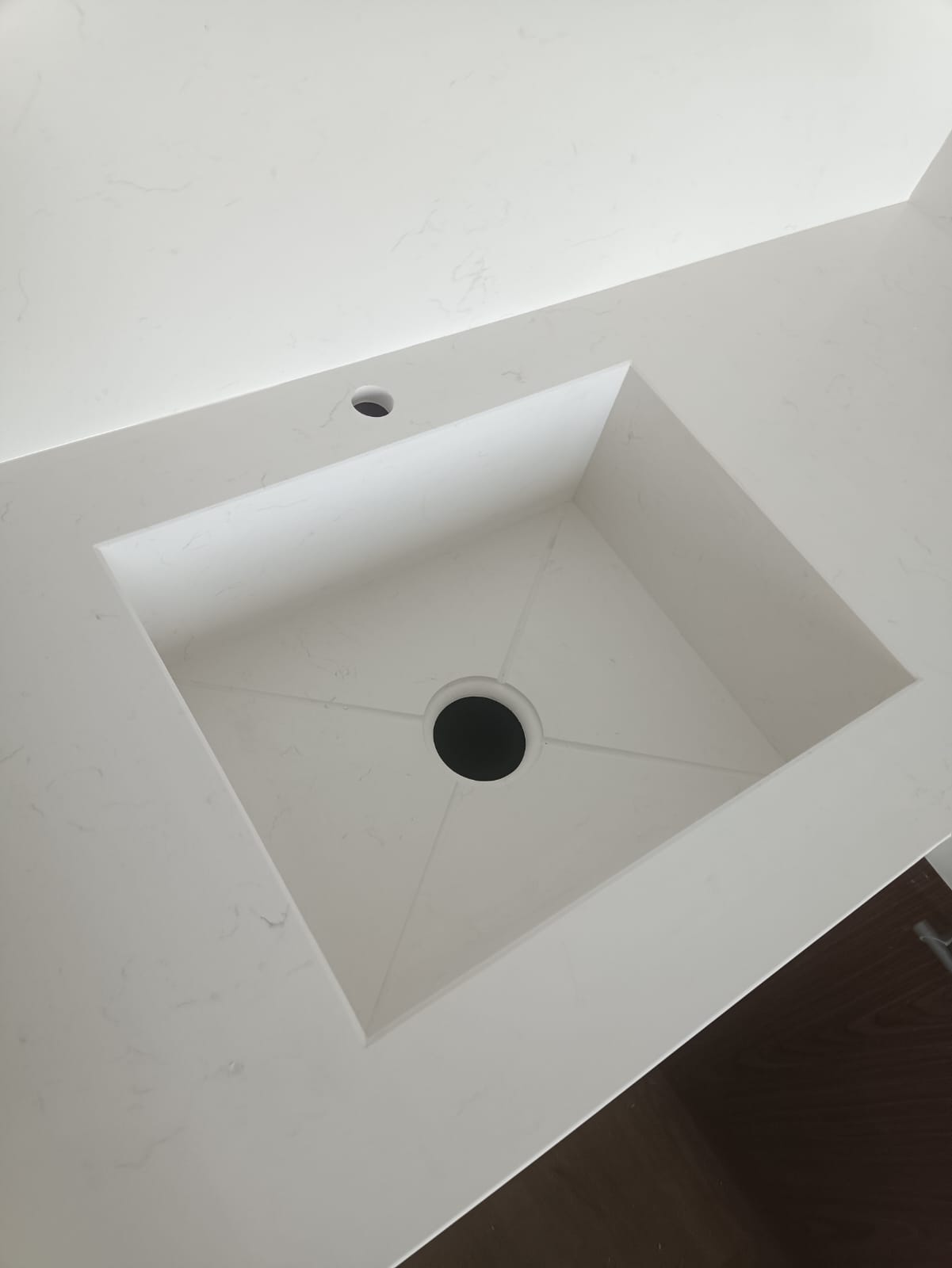 Крупный план интегрированной квадратной каменной мойки из кварца Аварус R541 Снега Сибири — чёрный слив, монолитная чаша