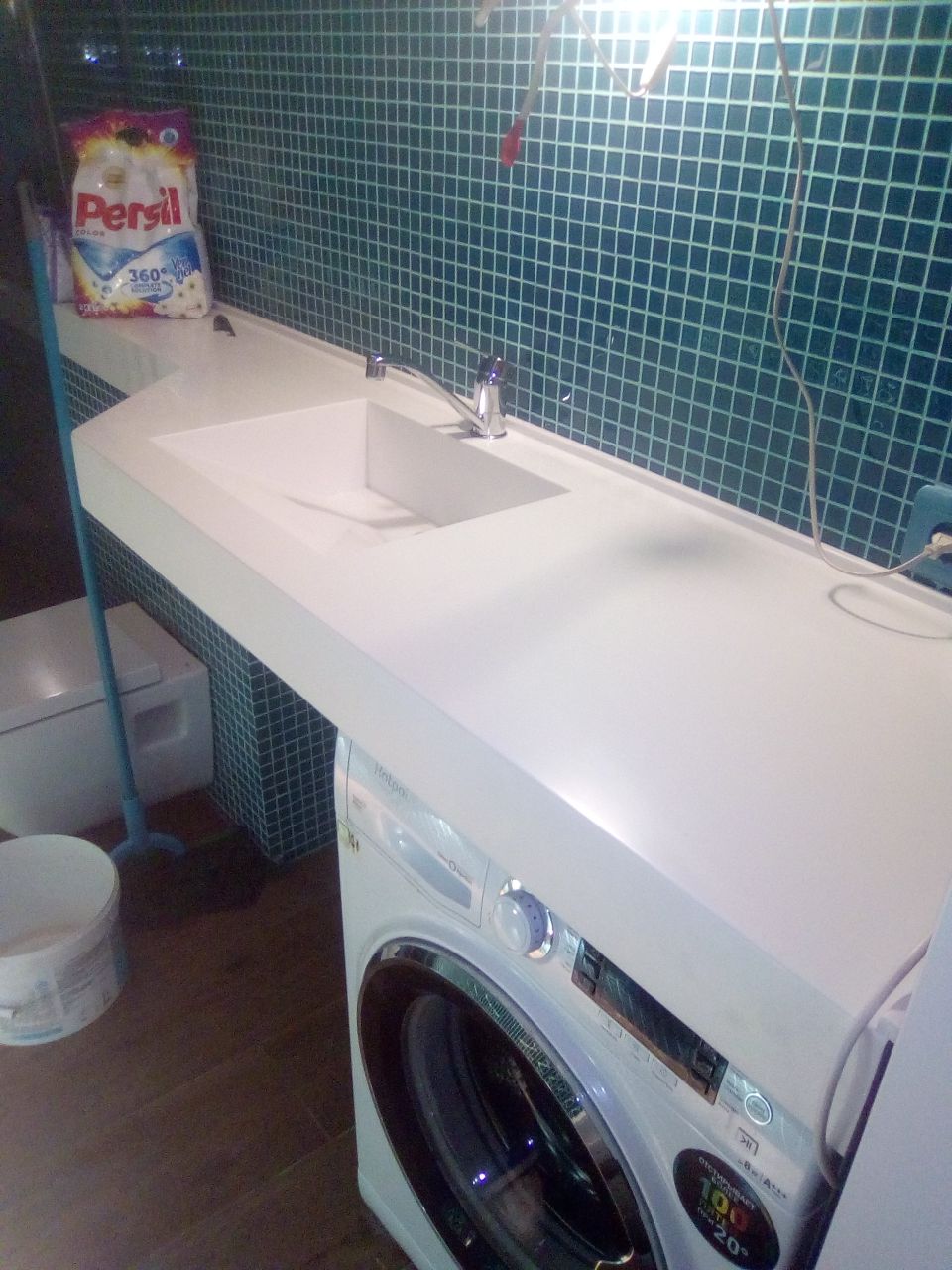 Столешница в ванную над стиральной машинкой из камня Столешница в ванную комнату из камня: накрывает стиральную машинку и сужается к дальней стенке