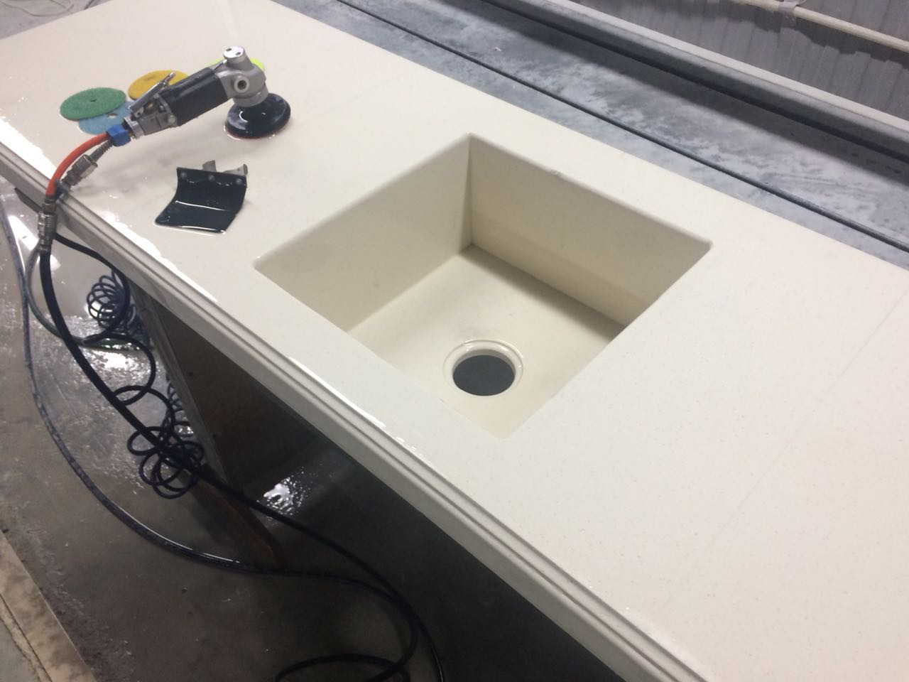 Мойка уже вклеенна в столешницу из камня: сейчас мастер начнет полировку