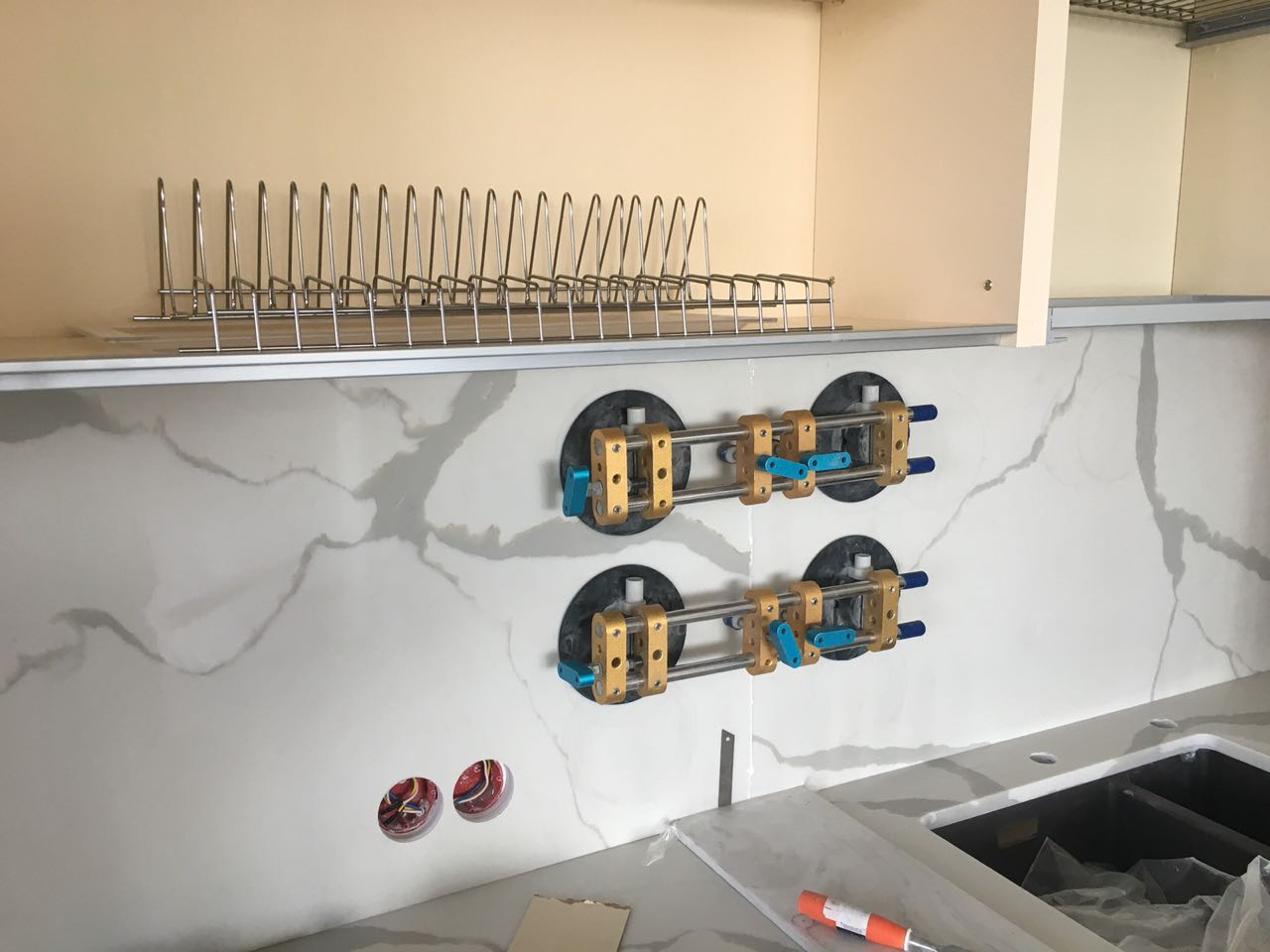 Стеновая панель из камня склеивается с помощью вакуумных стяжек: на детали нанесен клей, стяжки будут сняты, когда клей высохнет.