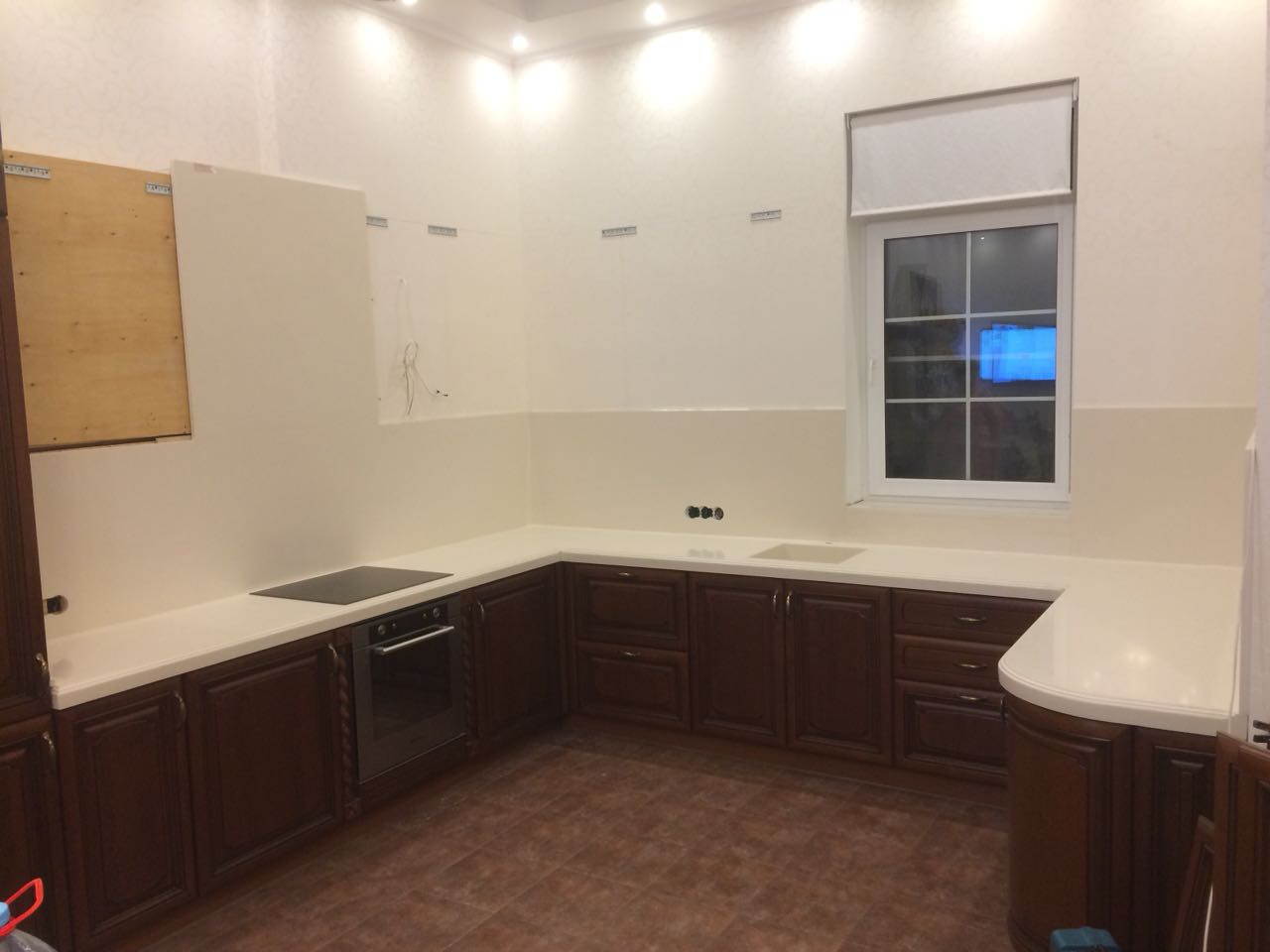 Фартук из камня в зоне варочной панели (вытяжки) установленный на столешницу из кварца