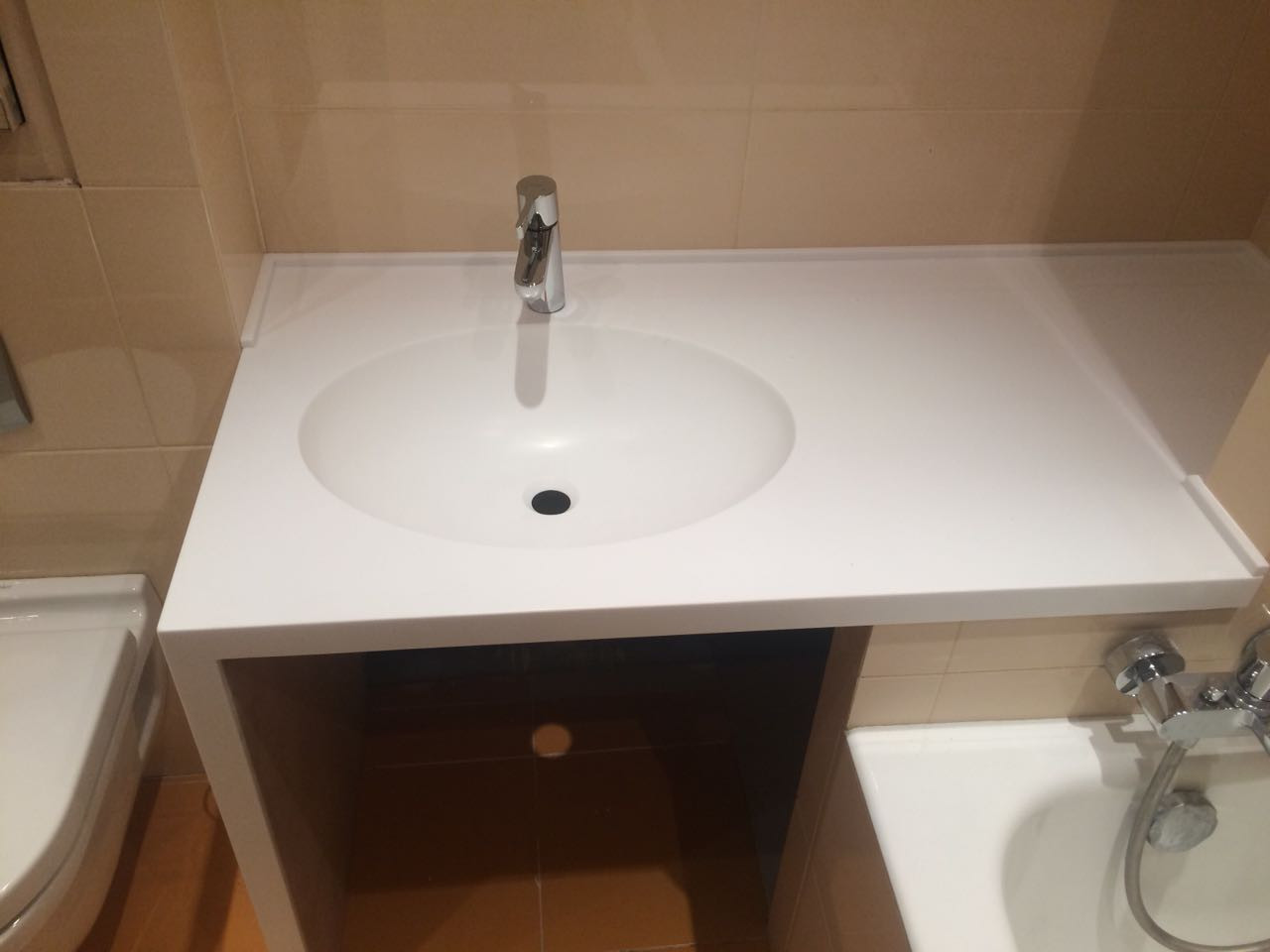 Вид спереди на столешницу с интегрированной мойкой Вид спереди на столешницу в ванную из искусственного камня с интегрированной мойкой