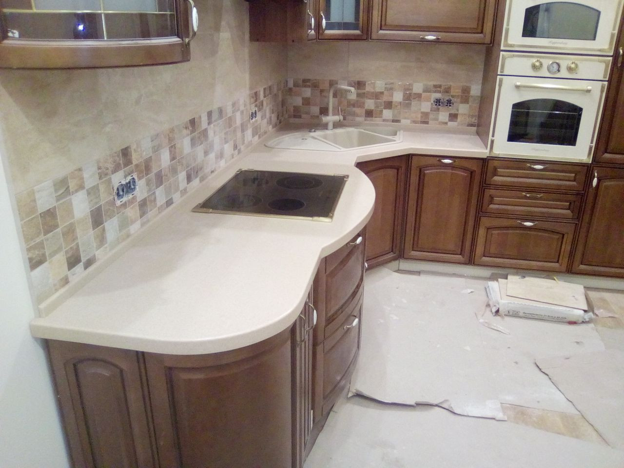 Вид сбоку на столешницу из искусственного камня: расширение в зоне варочной панели, угловая мойка